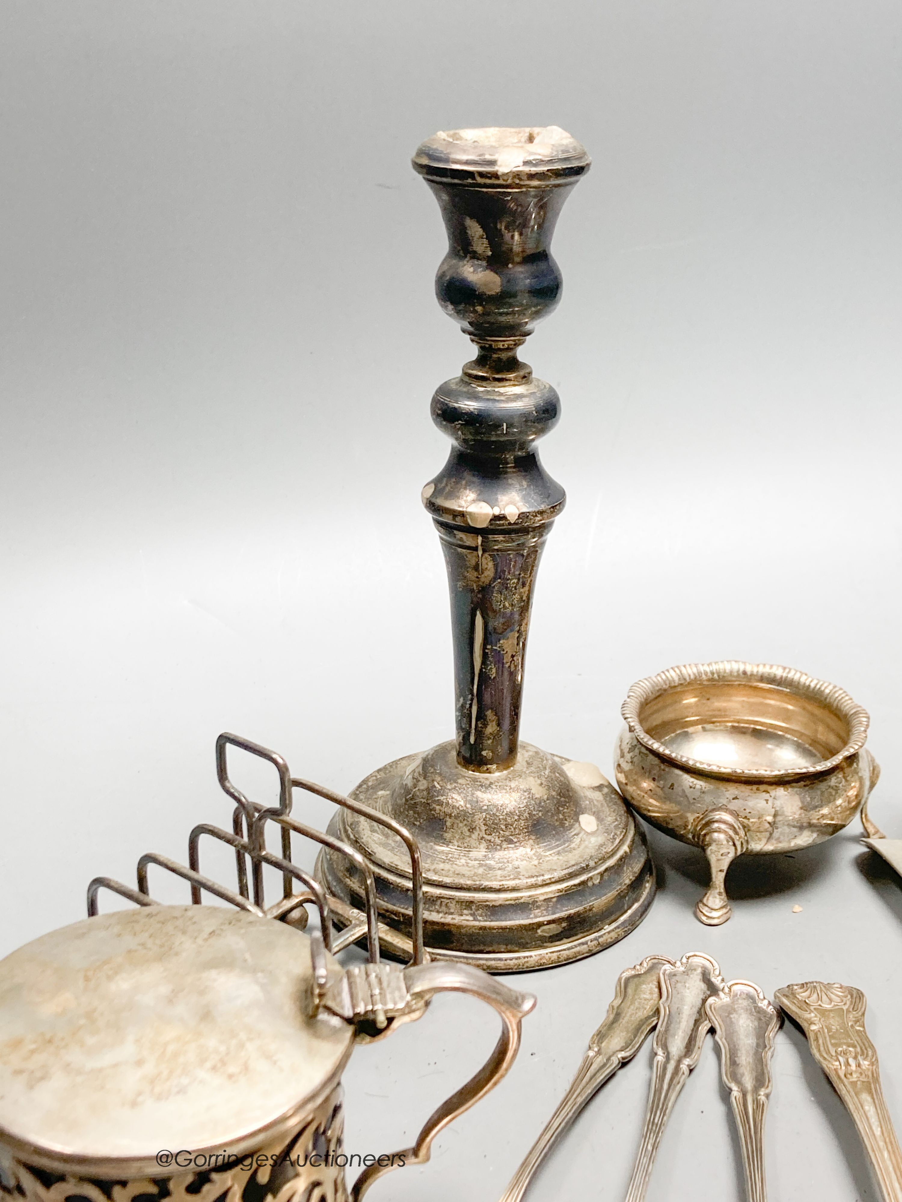 A collection of small silver, including a George V silver mustard, continental white metal and English silver flatware, toastrack, salt, inkwell etc. and a plated candlestick.